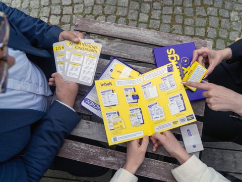 Menschen schauen auf Gesprächskarten zum Thema Demokratie