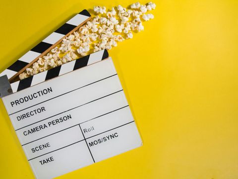 Filmklappe mit Popcorn auf gelben Untergrund