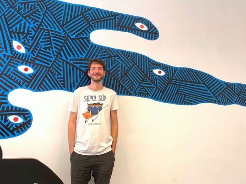 Ein Mann steht vor einer Comicwand