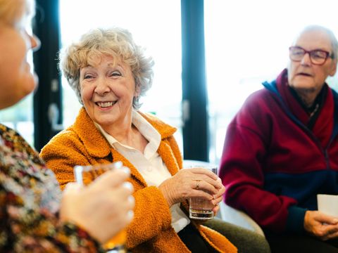 Ältere Menschen reden und lachen zusammen