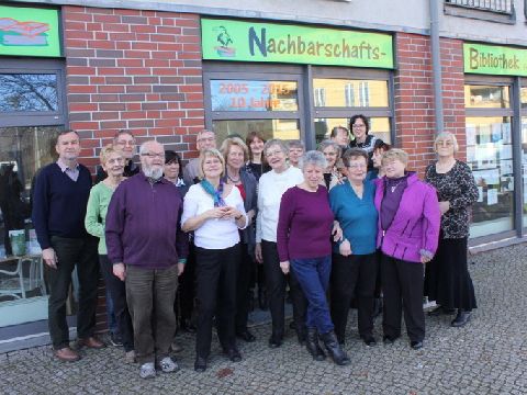 Nachbarschaftsbibliothek in Französisch Buchholz. Eine große Gruppe steht vor dem Gebäude.