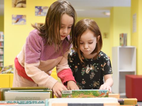 Zwei Kinder stöbern im Kinderbereich der Korczak-Bibliothek.