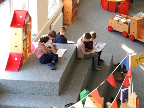 Auf dem Podest lesen Kinder in Büchern