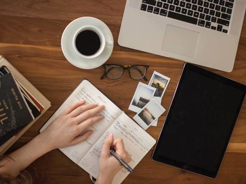 Tablet Notebook Kaffeetasse Buch auf einem Tisch
