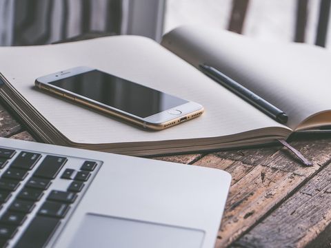 Tablet, Handy, Notizblock und Stift auf dem Schreibtisch