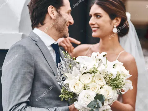 Flowers, wedding and love with a married couple standing outdoor together after a ceremony of tradition. Love, marriage or commitment with a man and woman outside looking happy as husband and wife