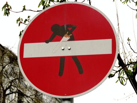 Verkehrschild Fahrverbot mit Männchen, das am weißen Balken sägt