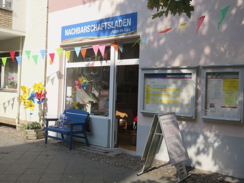 Eingangsbereich mit Bank und Eingangstür zum Nachbarschaftsladen