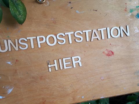 Schild mit Aufschrift Kunstpoststation
