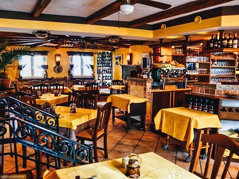 Innenbereich einen Restaurants mit vielen dunklen Stühlen und Tischen