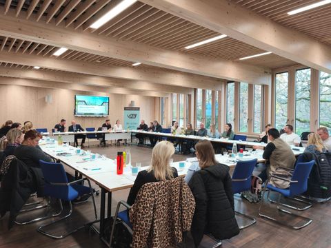Tag der Ausbildung 2025. Teilnehmende sitzen in Carré-Bestuhlung und unterhalten sich