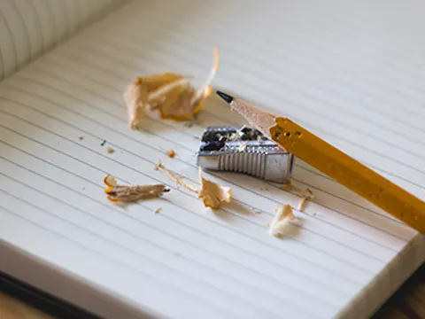 Bleistift mit Bleianspitzer auf einem Notizbuch