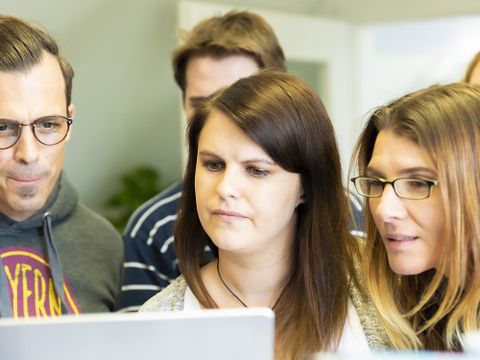 Fünf Personen vor Notebook