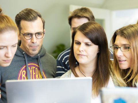 Fünf Personen vor Notebook