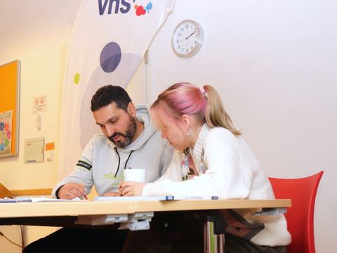 Ein Mann und eine Frau sitzen am Tisch und lesen