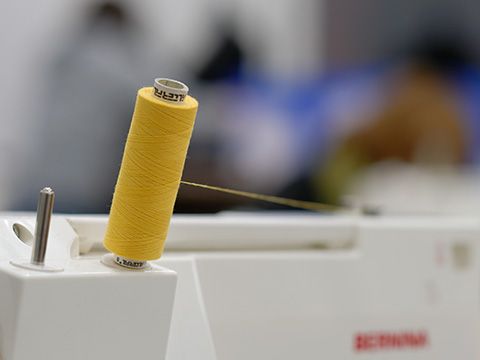Gelbe Garnrolle auf einer Nähmaschine