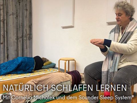 Kursleiterin Cornelia Michalek im Schlafseminar. Sie demonstriert mit aufeinander gelegten Händen eine beruhigende Geste.