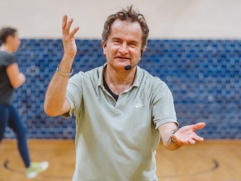 Kursleiter Karsten Prosche mit Headset und dynamischer Geste zur Anleitung von Energy Dance®