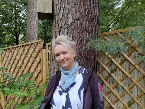 Portrait Wiebke Wiedeck im Garten vor Zaun