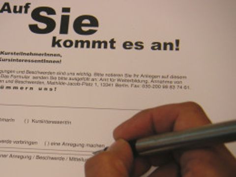 Nahaufnahme einer Hand, die mit einem Stift auf Papier schreibt.