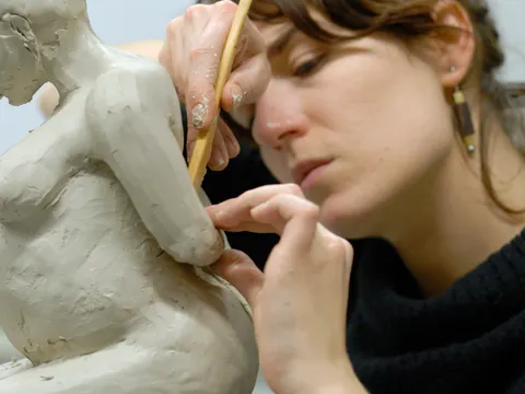 Eine Frau modelliert eine menschliche Figur