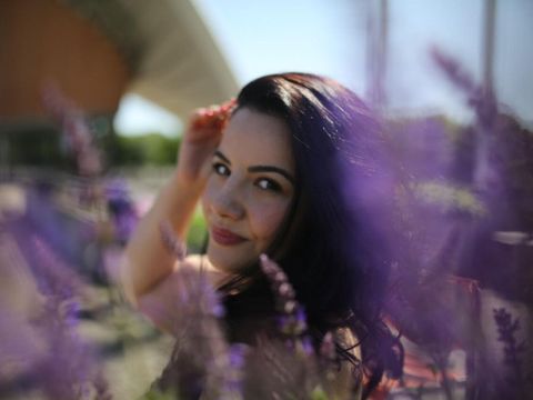 eine Frau zwischen lila Blumen