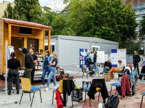Kurs draußen auf dem Hof in der Antonstraße, eine Gruppe von Menschen sitzt im Freien.