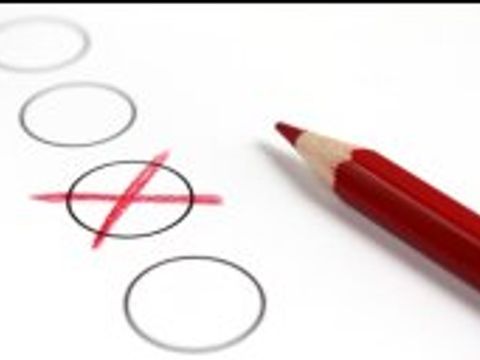 Stift liegt neben einem Papier, auf dem ein Feld angekreuzt wurde