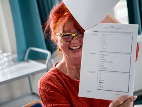 Frau hält Dokumente hoch