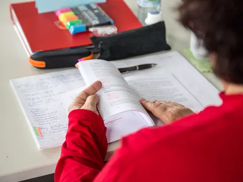 Person liest in einem aufgeschlagenen Buch
