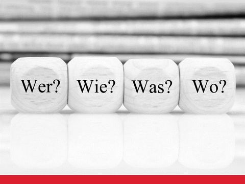 Vier Würfel mit den Fragen Wer? Wie? Was? Wo?