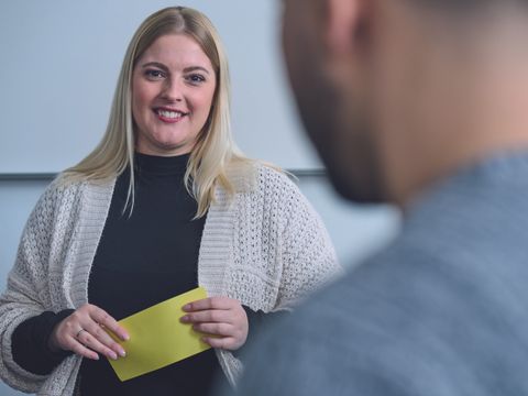 Eine Frau mit Moderationskarten in der Hand