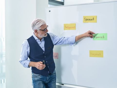 Kursleiter heftet Moderationskarte an Whiteboard