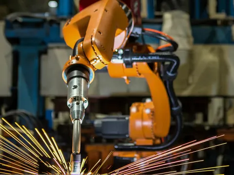 An industrial robot welds parts in a factory