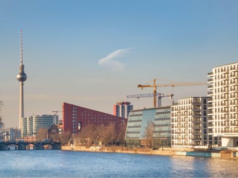 Auf dem Bild ist die Skyline von Berlin mit der Spree und dem Fernsehturm zu sehen.