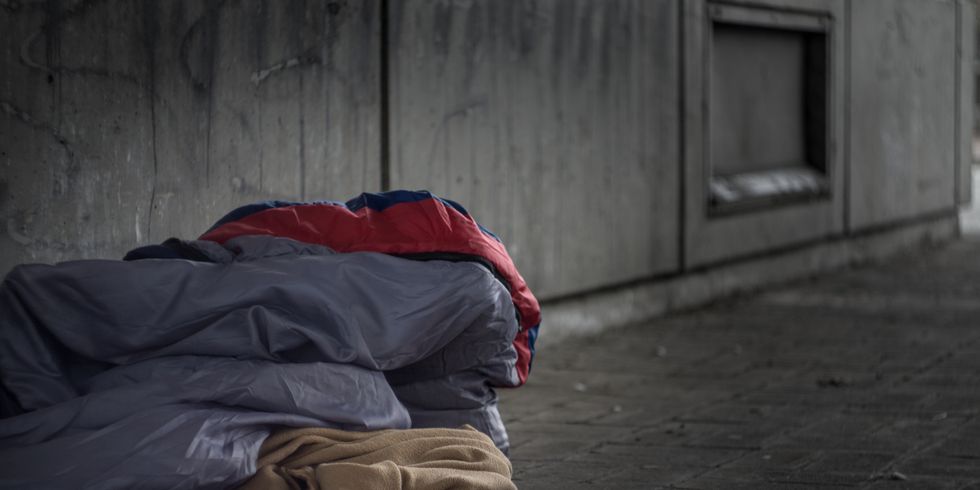 Armut auf den Straßen einer Stadt: Schlafsäcke und Decken auf dem Boden unter einer Unterführung