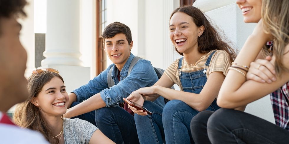 Junge Freundesgruppe sitzt zusammen und lacht