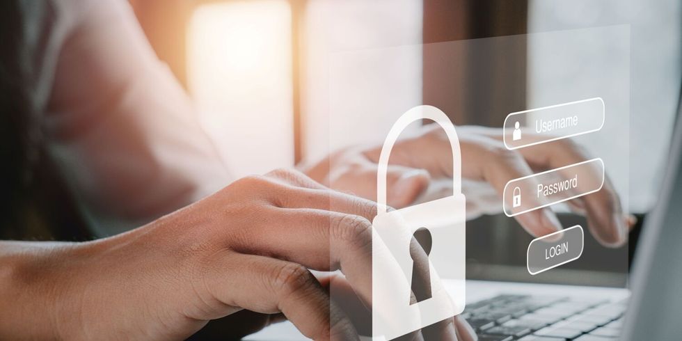 Frauenhand tippt auf einer Tastatur, während auf dem Bildschirm Login und Passwort angezeigt werden