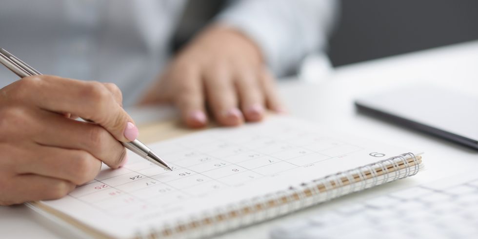 Eine Person schaut auf einem Tischkalender ein Datum nach