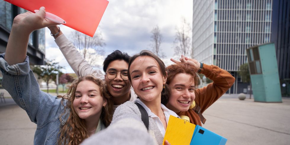 Vier lachende Studenten machen ein Selfie