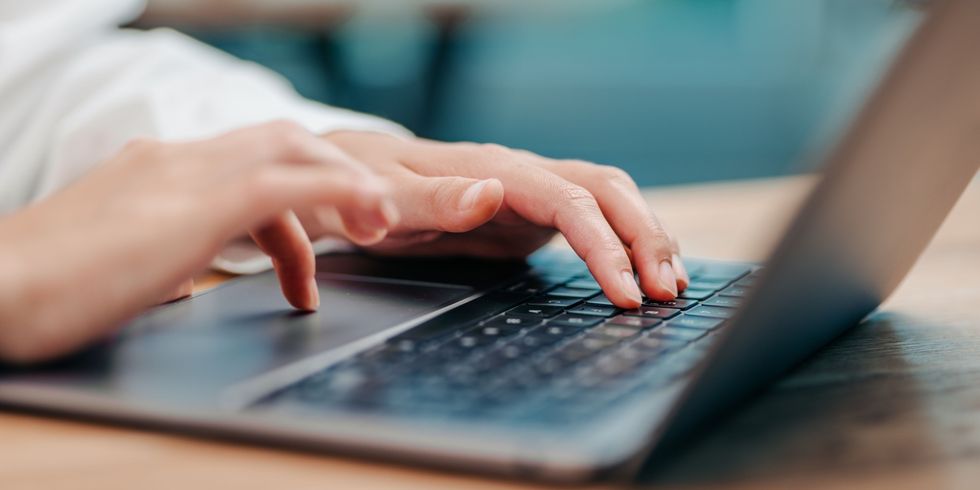Hände tippen auf der Tastatur eines Laptops