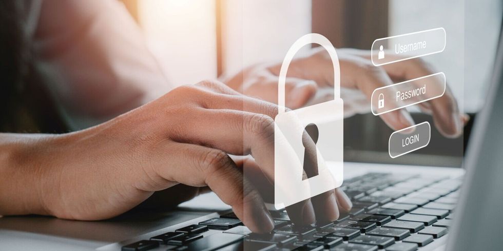 Frauenhand tippt auf einer Tastatur, während auf dem Bildschirm Login und Passwort angezeigt werden
