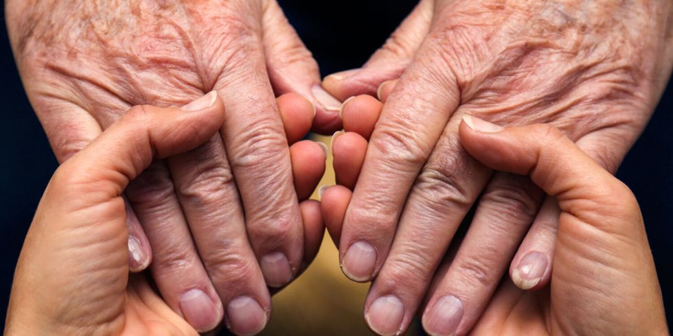 Die Hände einer Frau spenden Kraft und Trost, und die eines älteren Herrn