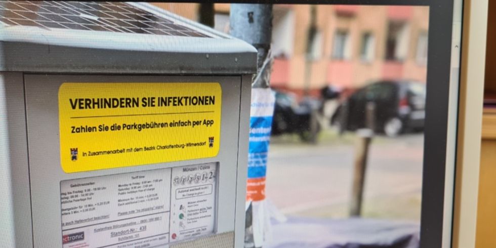 Neue gelbe Sticker auf den Park-Automaten werben für kontaktloses Bezahlen.