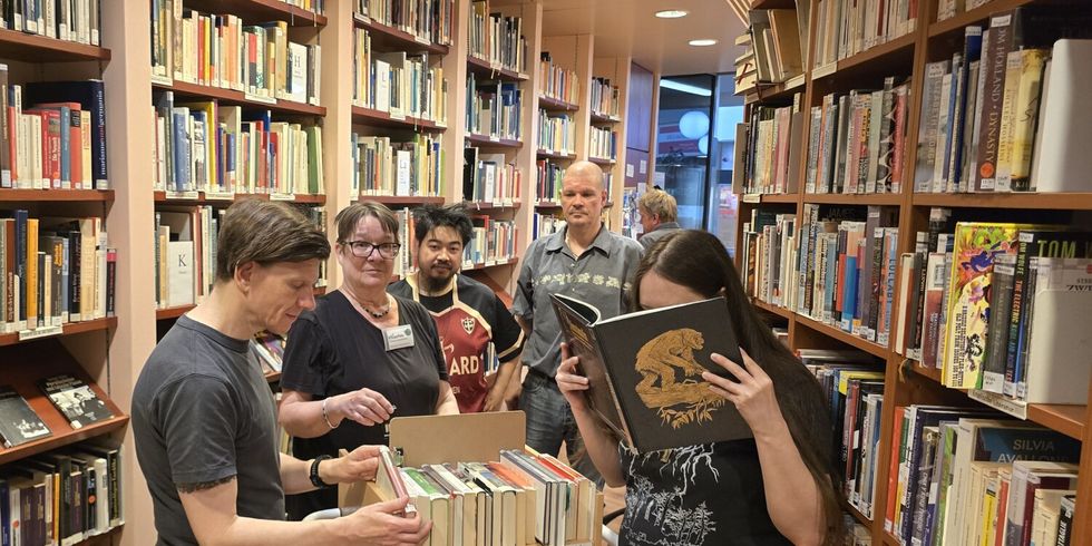 Gemeinsam bestückt das Team der Patientenbibliothek den kleinen Rollwagen mit den neuesten Schmökern für den Stationsbesuch
