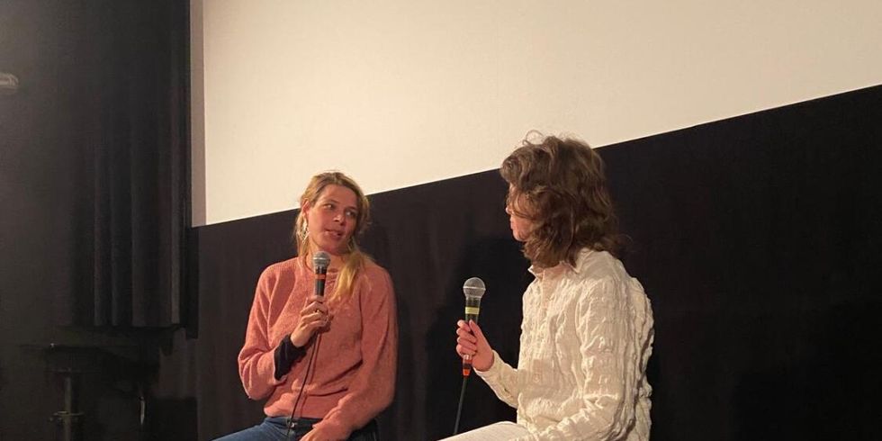 Zwie personen während einer Diskussionveranstaltung vor der weißen Leinwand in einem Kino