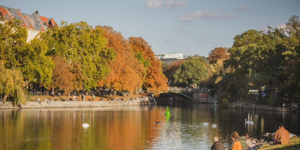 Menschen sitzen am Landwehrkanal im Herbst