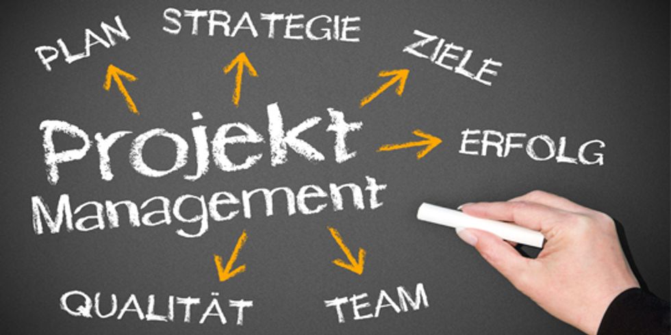 Tafel auf der in der Mitte Projekt Management steht und drum herum kreisförmig angeordnet Begriffe zum Thema