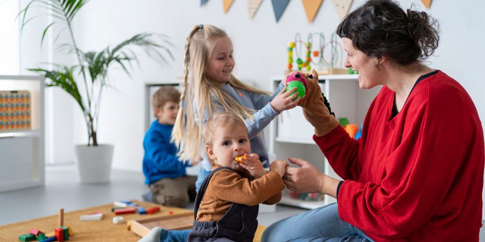 Kinder lernen und spielen mit Erzieherin