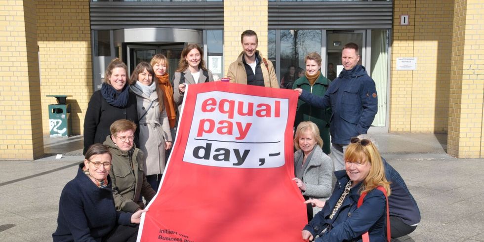 Fahnenhissung zum "Equal Pay Day 2024" - Juliane Witt, Heike Wessoly, Gordon Lemm, Stefan Bley und die Beauftragten Maja Loeffler und Vanessa Krah halten die Fahne